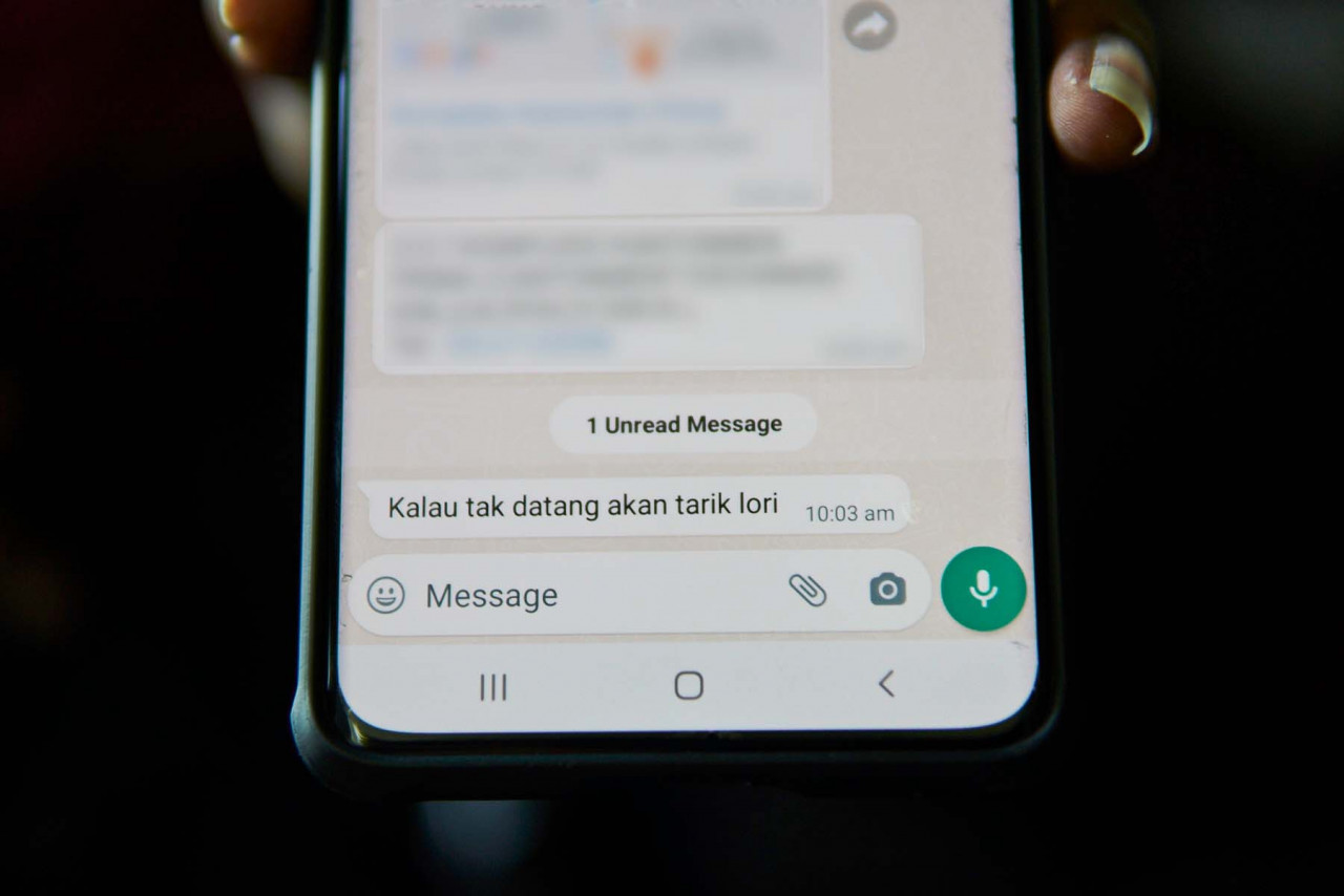 Dayalan Kumar Ganeson shows a text message he received from the leasing company, threatening to repossess their lorries if no payment is made. – The Vibes pic, January 28, 2022