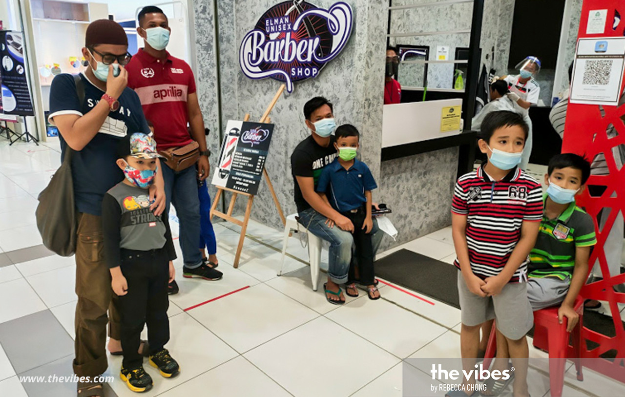 No cutting of queues here as parents wait their turn for their children to get haircuts at the Mydin Hypermarket barber shop. – REBECCA CHONG/The Vibes pic, February 28, 2021