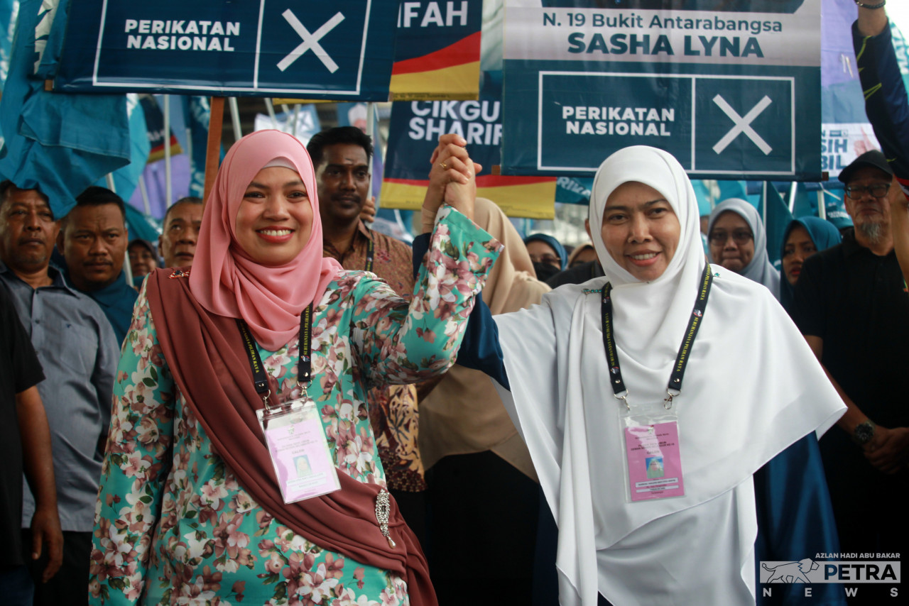 Sasha Lyna Abdul Latif (left) and Sharifah Haslizah Syed Ariffin (right) during their candidate walkabout today, flanked and followed by Perikatan Nasional supporters.– AZLAN HADI ABU BAKAR/The Vibes pic, July 29, 2023