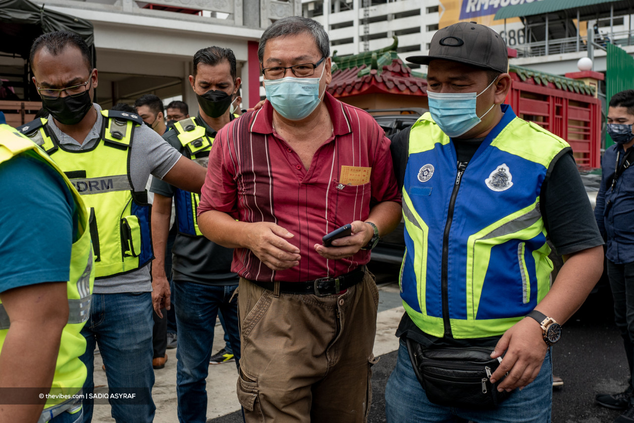 A man being escorted from the premises by police at the temple today. – SADIQ ASYRAF/The Vibes pic, September 29, 2021