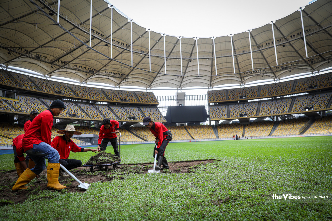 Workers carefully dig out the grass from the football pitch of the Bukit Jalil National Stadium. – SYEDA IMRAN/The Vibes pic, March 31, 2023