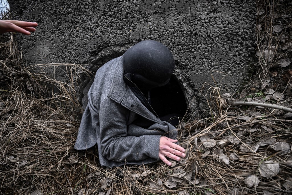 A journalist takes cover during shelling in the city of Irpin, northwest of Kyiv, on Saturday, ten days after Russia launched a military invasion on Ukraine. – AFP pic, March 7, 2022