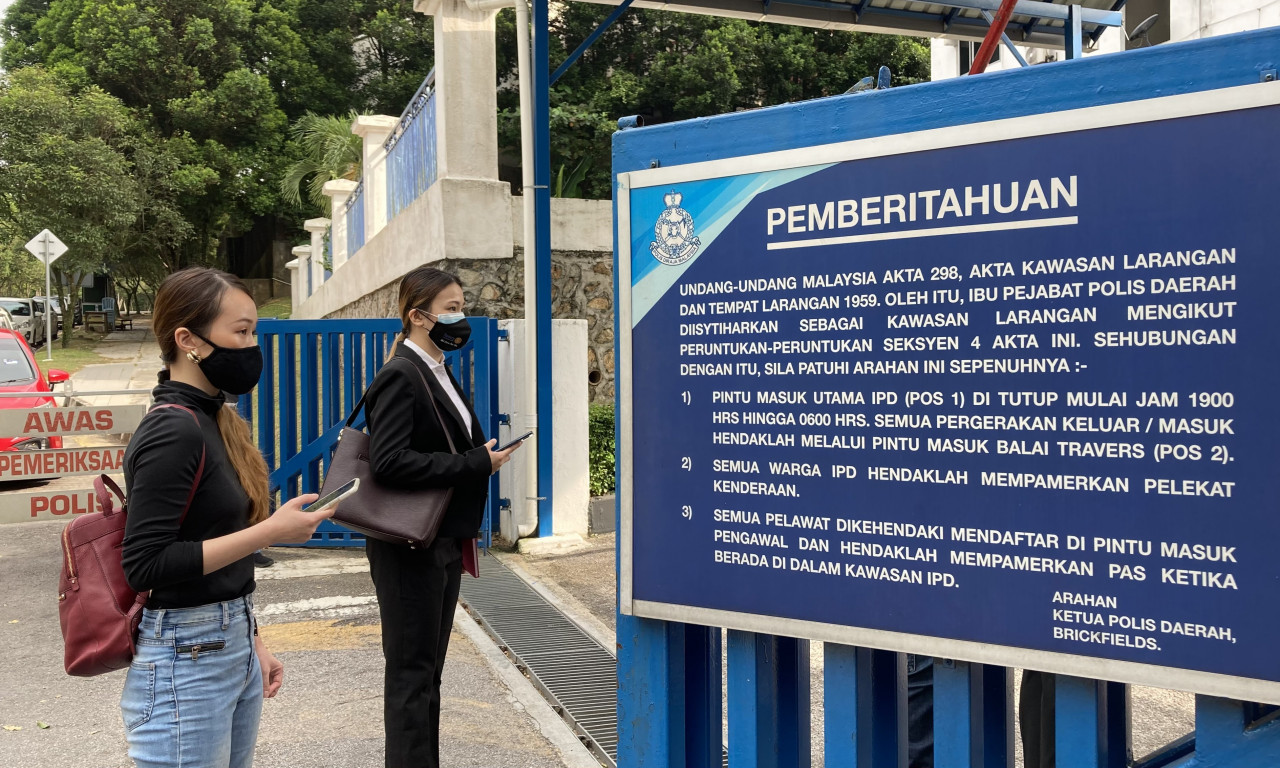 A lawyer and her client, who participated in the #Lawan convoy, stand at the gates of the Brickfields police station in Kuala Lumpur. – LANCELOT THESEIRA/The Vibes pic, July 26, 2021