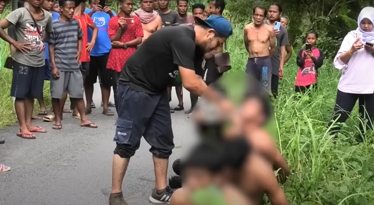 A samaritan gives water to a few escapees of the Bidor immigration depot who were caught near an Orang Asli village in Perak. – Malaysia Gazette screen grab pic, February 7, 2024. 