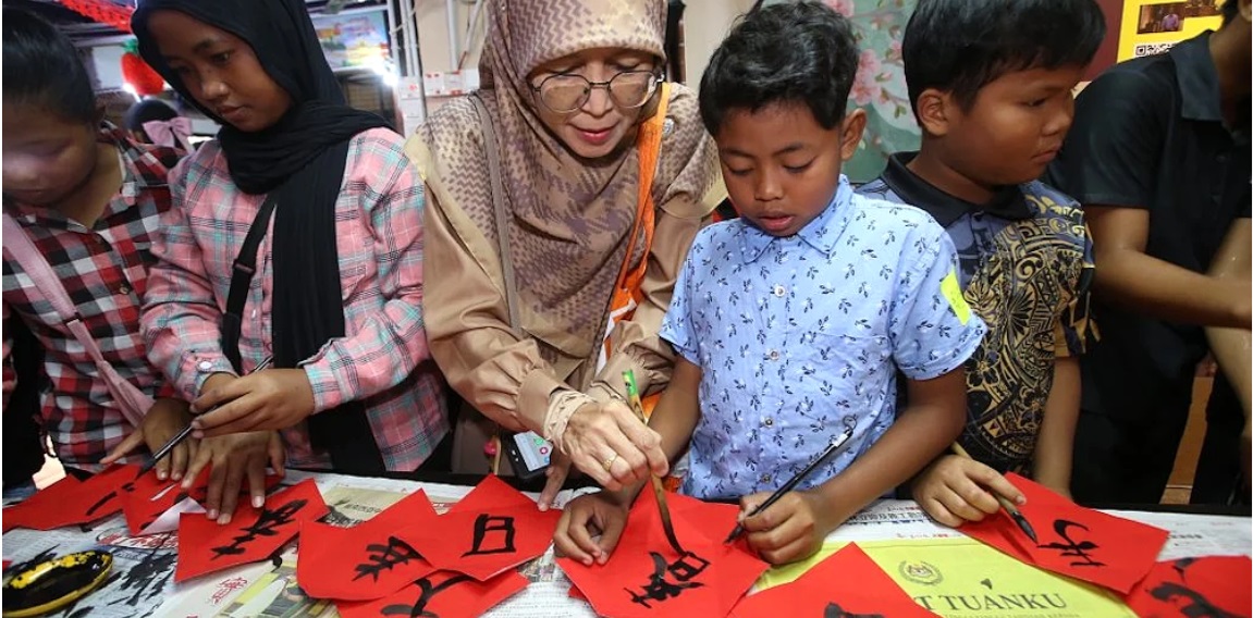 A Malay teacher and a student trying their hand at Chinese calligraphy. – Sin Chew Daily, February 22, 2024. 