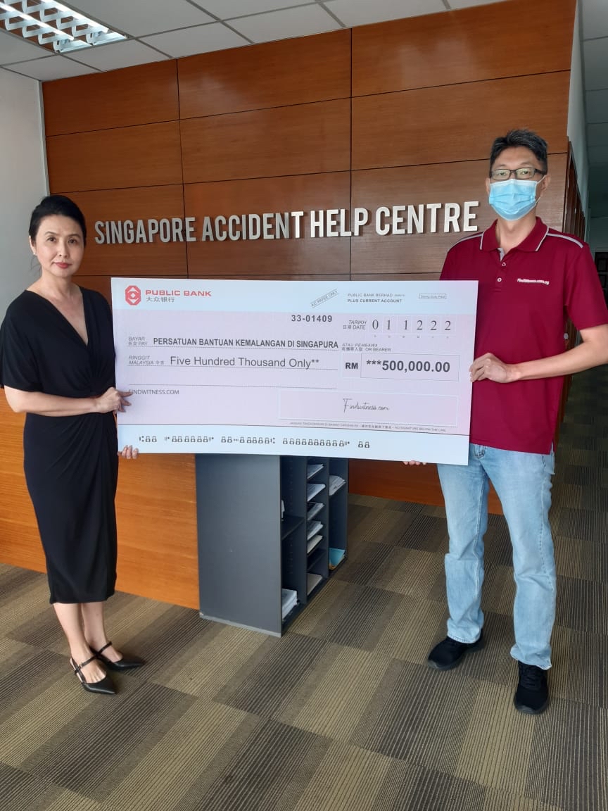 Singapore Accident Help Centre chief operating officer Janey Wong (left) receives a mock cheque of RM500,000 from FindWitness representative Chen Li Wei for the centre’s work in ensuring Malaysian workers in Singapore get fair treatment when suffering accidents. Wong says any Malaysians working in the Lion City should not be afraid to seek medical treatment there if they become involved in an accident. – Pic courtesy of Singapore Accident Help Centre, December 24, 2022