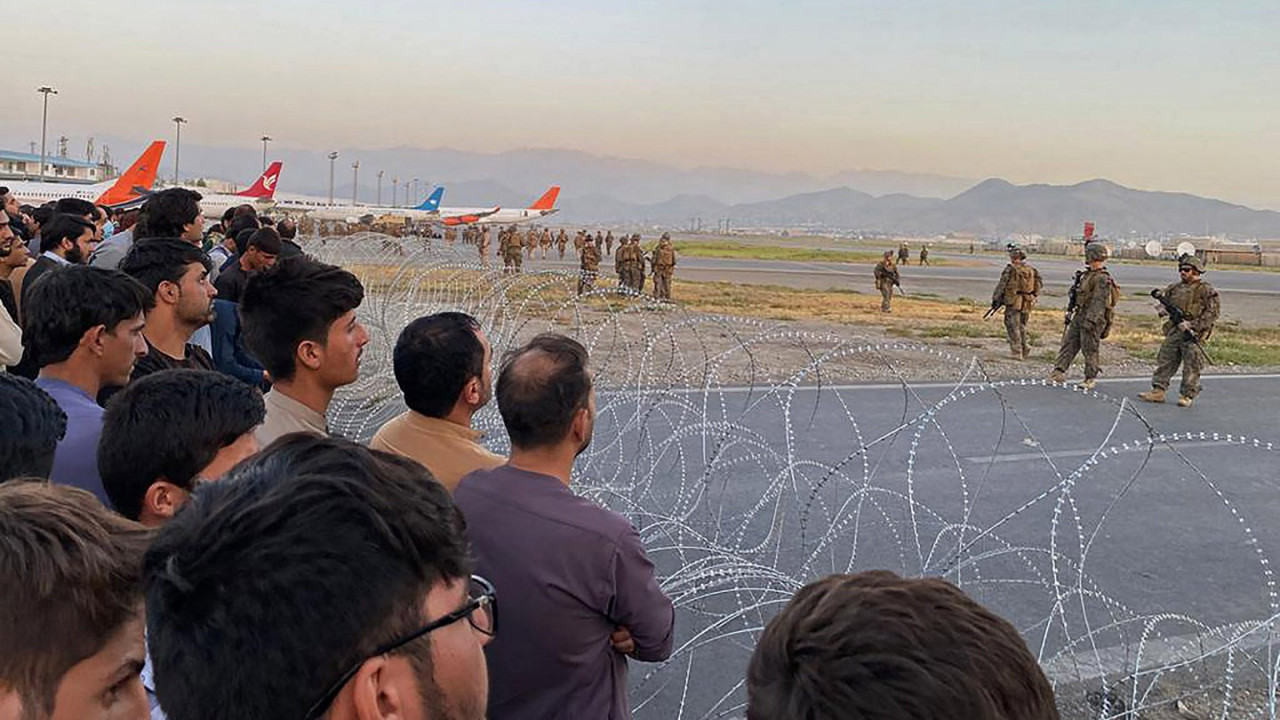 Afghans looking on as US soldiers stand guard at Kabul airport. – AFP pic, August 22, 2021