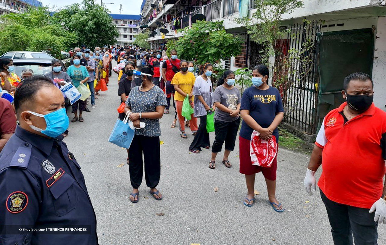 Long lines of people practising social distancing while waiting to receive their ration of vegetables at the Taman Kem flats in Klang. – TERENCE FERNANDEZ/The Vibes pic, July 15, 2021