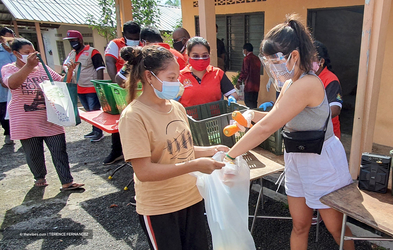 Tara Sekhar (right) helping out in the distribution of vegetables to the Orang Asli community at the Pulau Indah Orang Asli settlement in Klang. – TERENCE FERNANDEZ/The Vibes pic, July 15, 2021