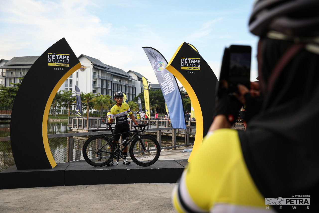 A participant poses at the L’Étape Malaysia photo arch erected at Desaru Coast, Johor. – SYEDA IMRAN/The Vibes pic, June 3, 2022