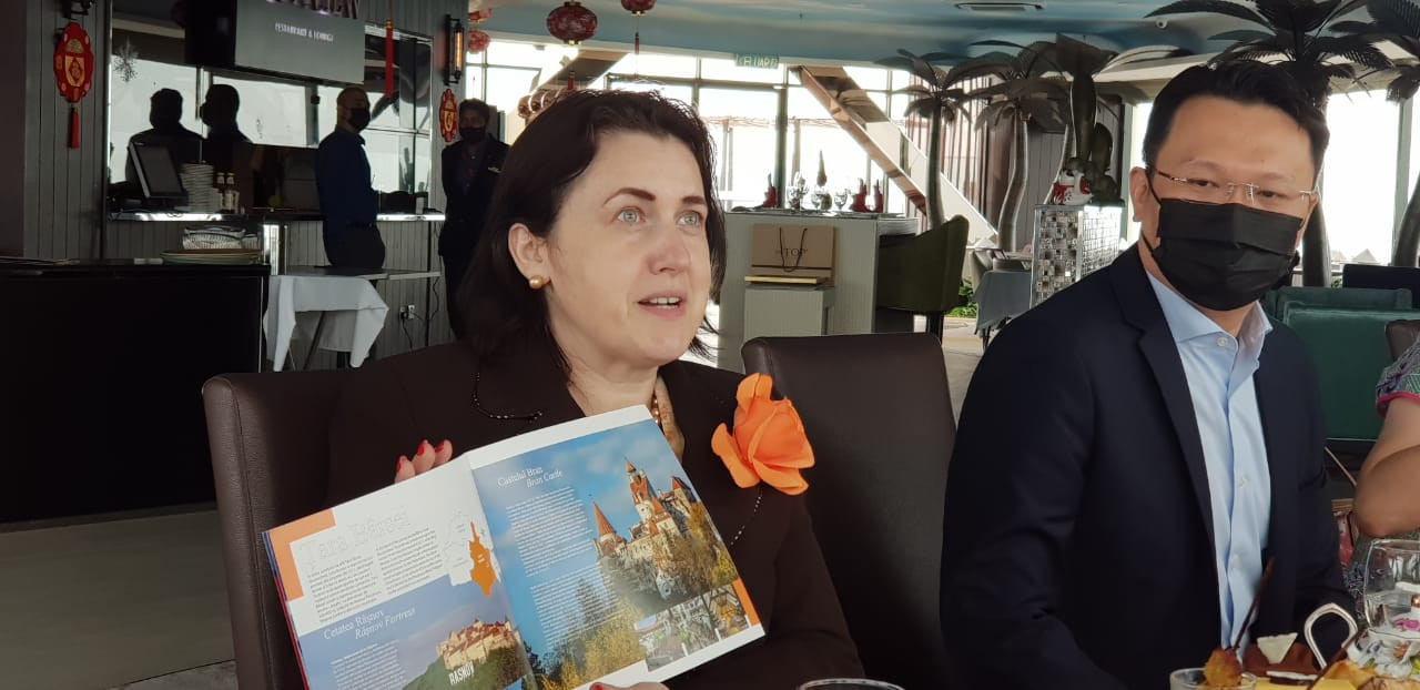 Romanian ambassador Nineta Barbulescu (left) shows a picture of the famed Bran Castle in Romania, commonly known as Dracula’s castle. – Pic courtesy of the office of Yeoh Soon Hin, February 16, 2022
