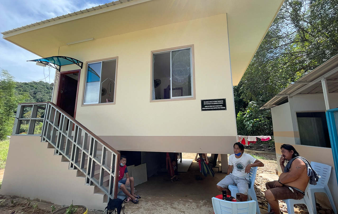 36-year-old Juraimi Ahmad (centre) sitting in front of his new home built by the Osimal Foundation. – The Vibes pic, November 17, 2021