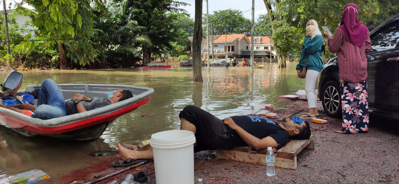Those just rescued from their homes in Taman Sri Muda can be seen sitting by the road taking a break. – ARJUN MOHANAKRISHNAN/The Vibes pic, December 20, 2021