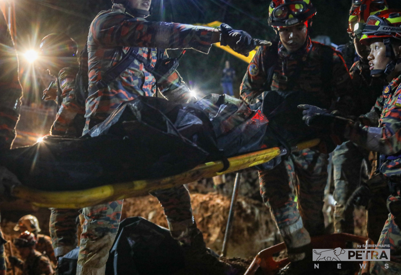 Batang Kali landslide rescuers lift the 25th victim’s body away on a stretcher after digging through a 16m-deep muddy terrain. – SAIRIEN NAFIS/The Vibes pic, December 21, 2022