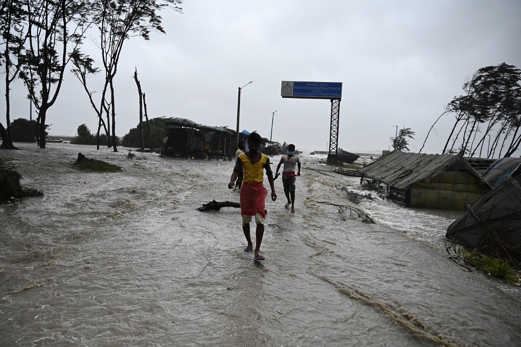 Residents at a beachfront as sea water reaches a nearby road while Cyclone Yaas barrels towards the area. – AFP pic, May 26, 2021
