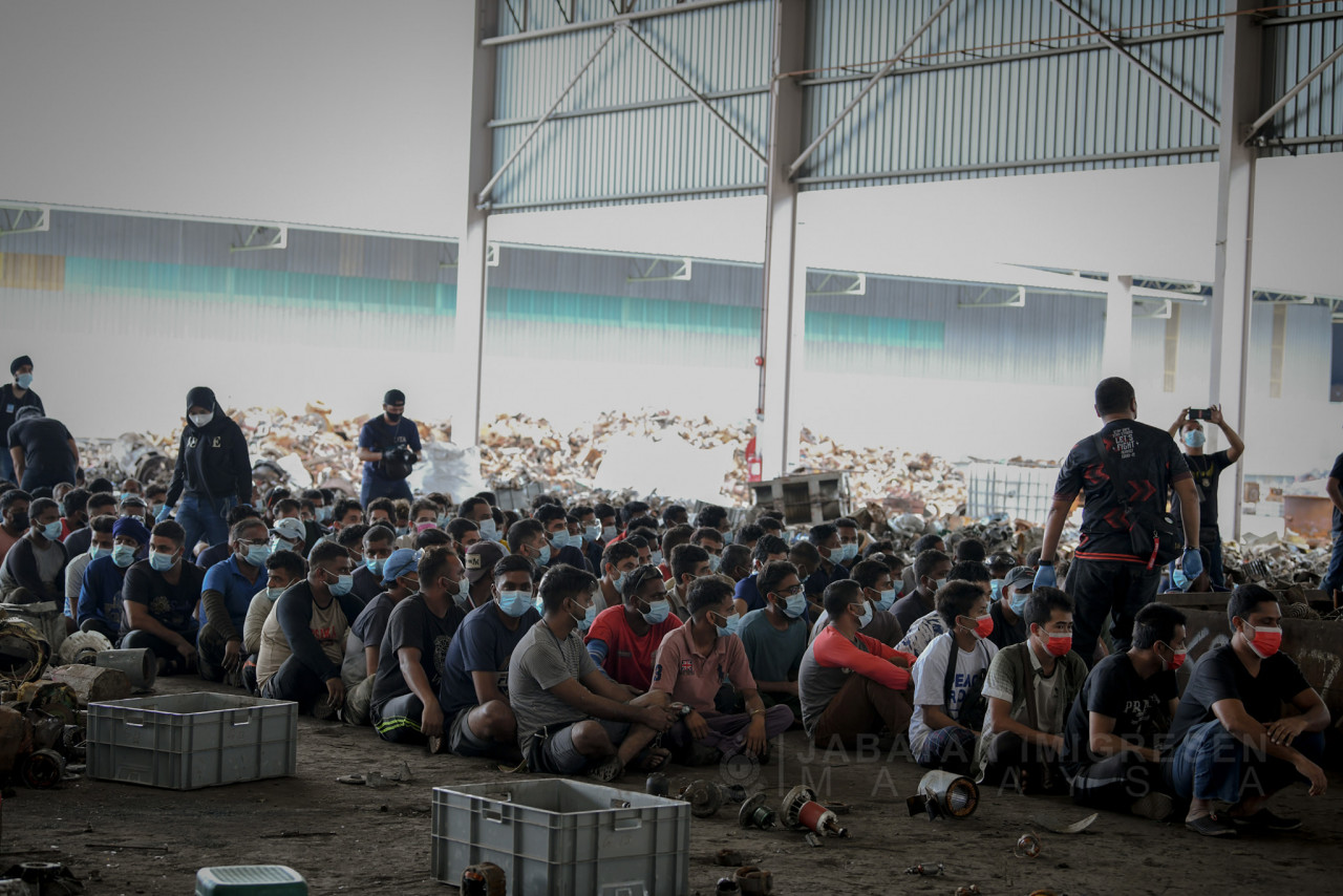 Some of the workers at the Meru factory awaiting the authorities’ orders during a raid today. – Immigration Department Facebook pic, June 30, 2021