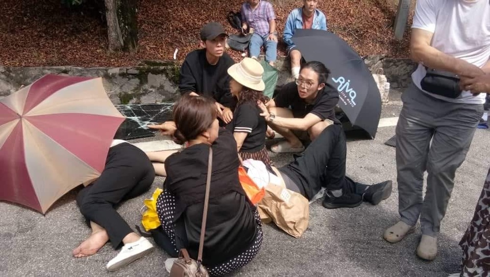 Injured passengers wait for help on the side of the road after the bus they were travelling in crashed in Jalan Genting-Bentong, today. – Facebook pic, June 29, 2024.