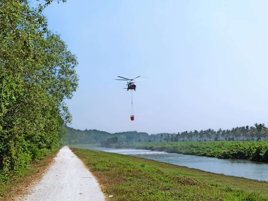 Water bombing being carried out in an attempt to douse the Pulau Burung landfill blaze; an effort that was unable to fully extinguish the fire due to the hot spell. – The Vibes pic, January 21, 2022