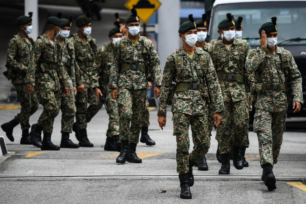 Soldiers leaving a police station to be deployed to man roadblocks during the MCO in Kuala Lumpur on March 22, last year, amid fears over the spread of the Covid-19 novel coronavirus. – AFP pic, March 18, 2021
