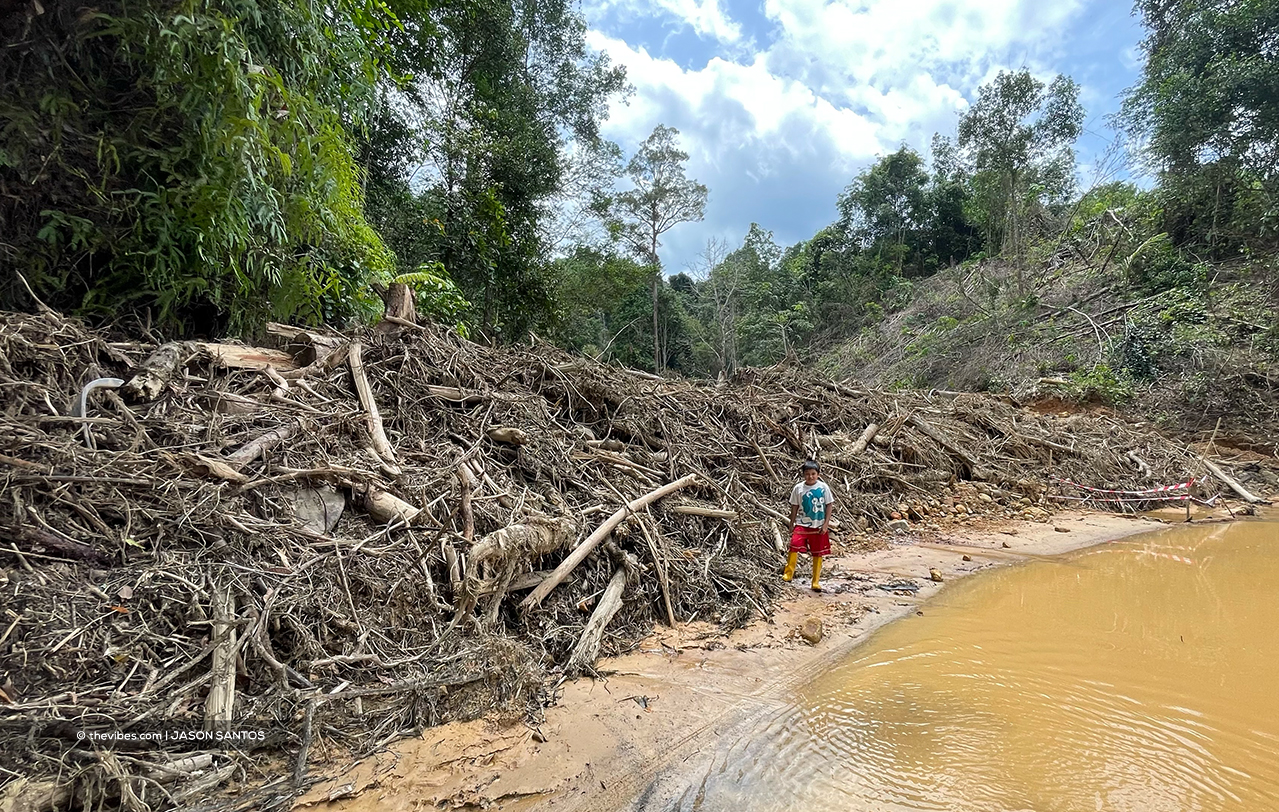 Jeremiah Luke, 11, whose grandfather is monitoring cleaning work involving a clogged stream behind their home in Kg Kodou. – JASON SANTOS/The Vibes pic, October 12, 2021