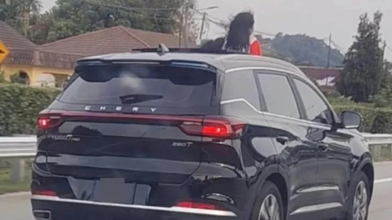 Mother arrested after viral video shows children standing through moving car sunroof