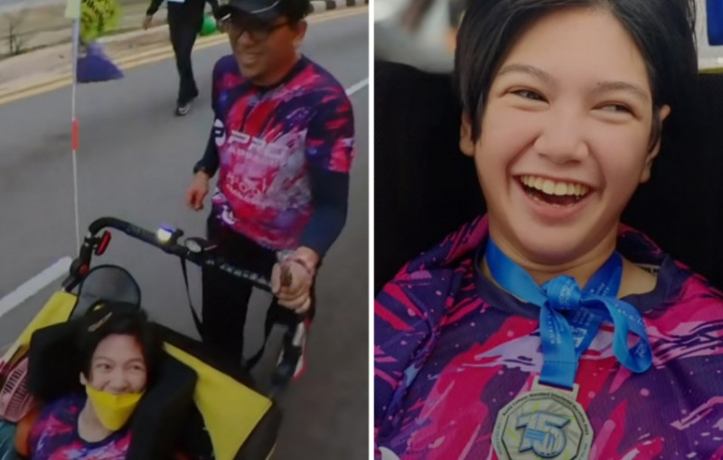 Father carries wheelchair-bound girl at marathon finish line