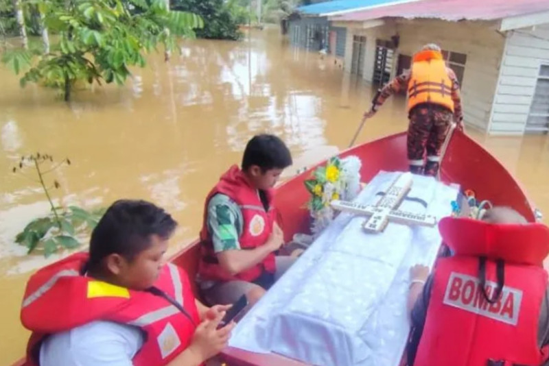 Sarawak rescue personnel help transport coffin in floods