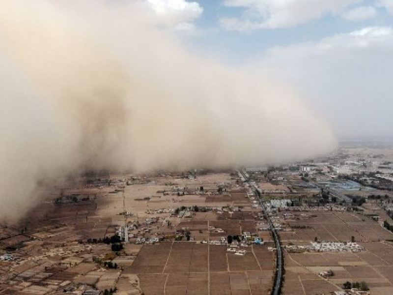 Apocalyptic scene as wall of sand engulfs China town