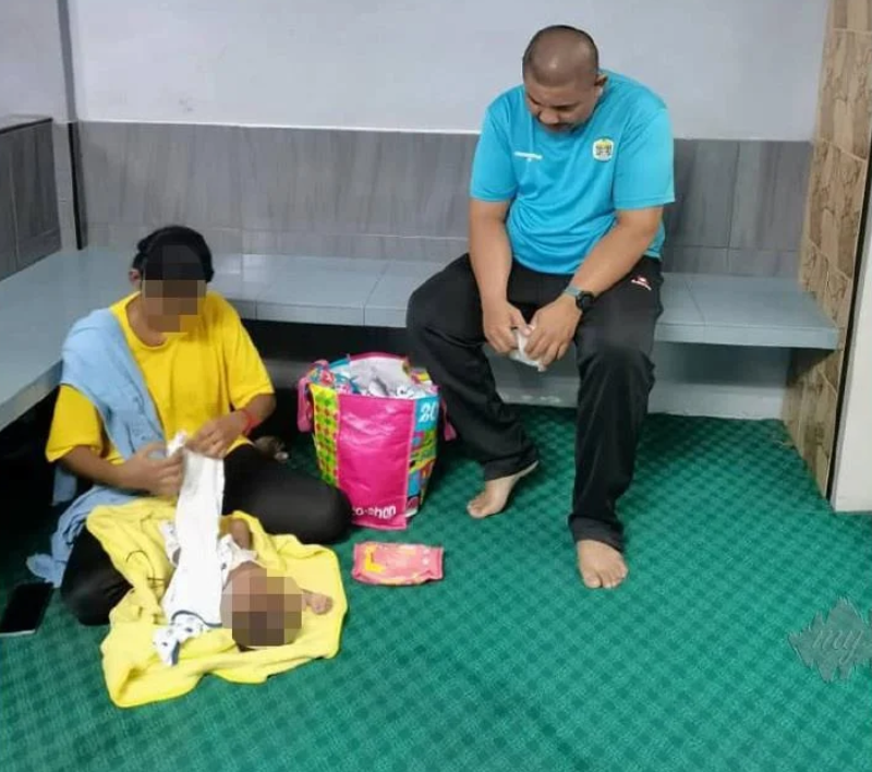 Young Indian mother with baby receives help from Alor Setar surau committee